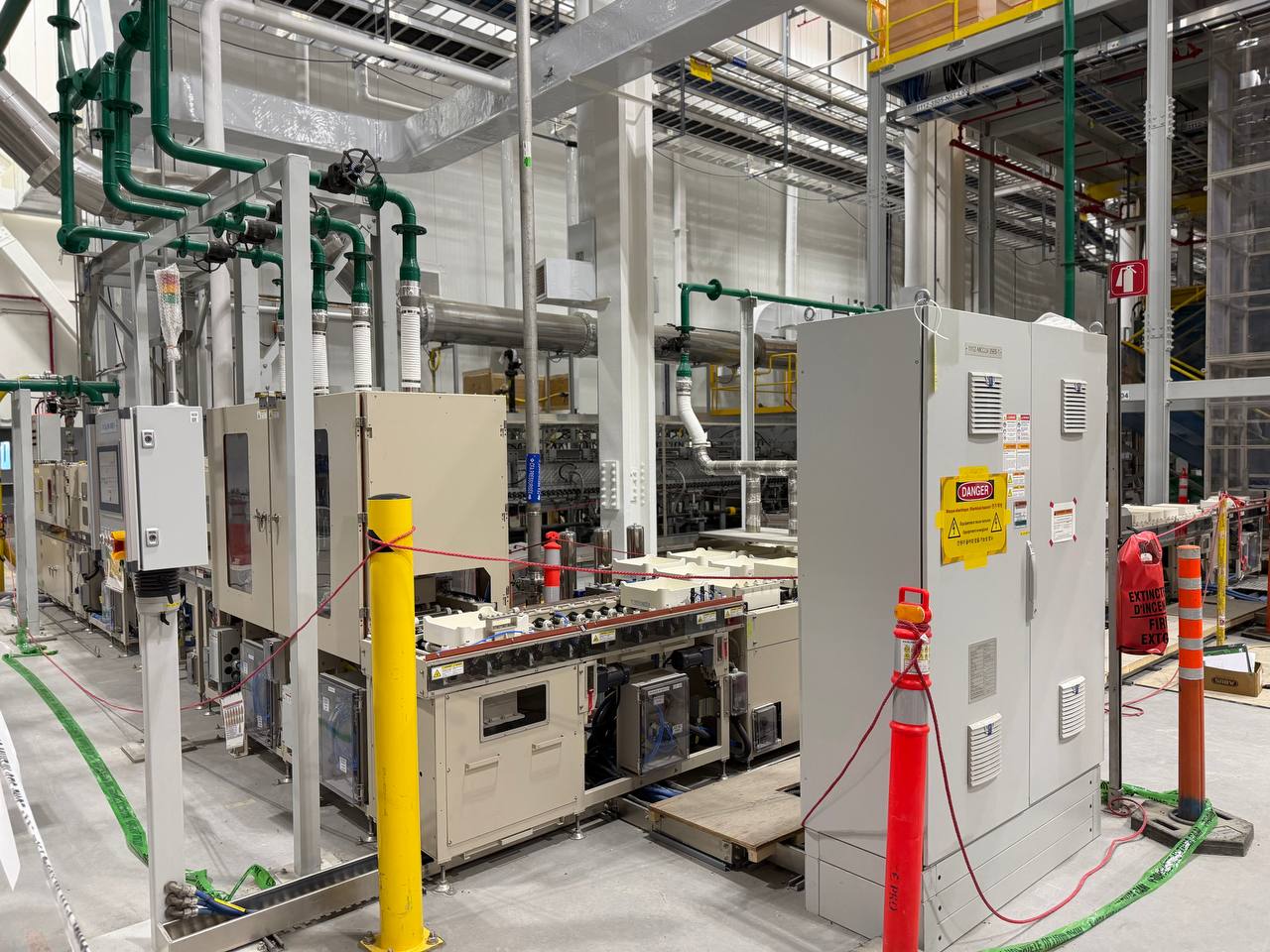 Packaging line on a plant floor with control cabinets and process piping