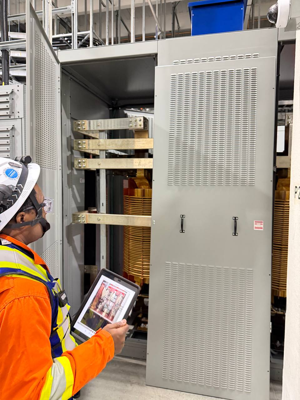 Technician inspecting a dry-type transformer with a tablet