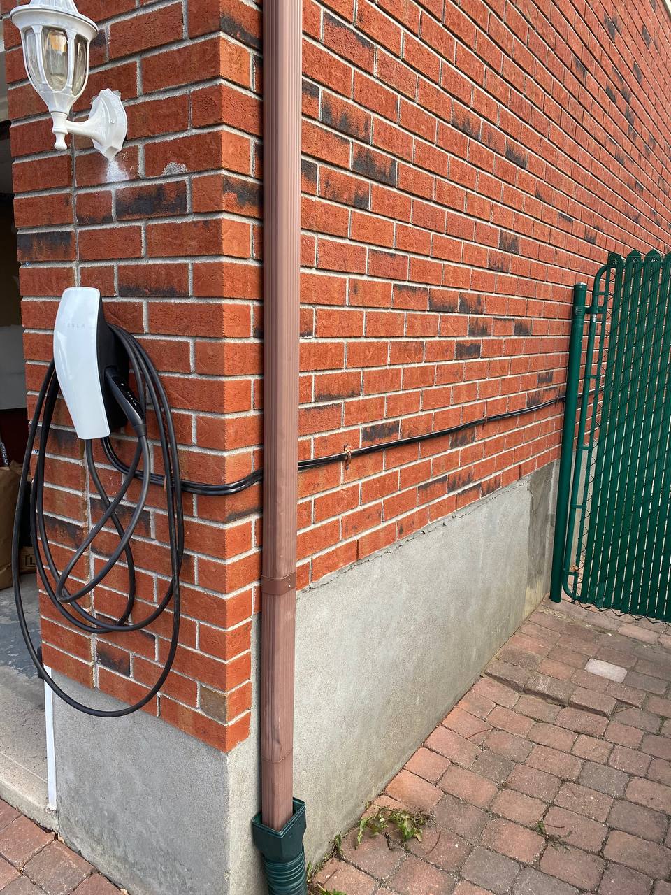 EV charger installed on the brick exterior of a home