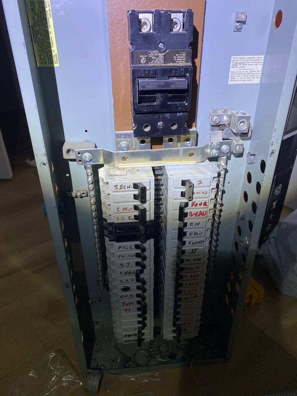 Older residential electrical panel with labelled breakers
